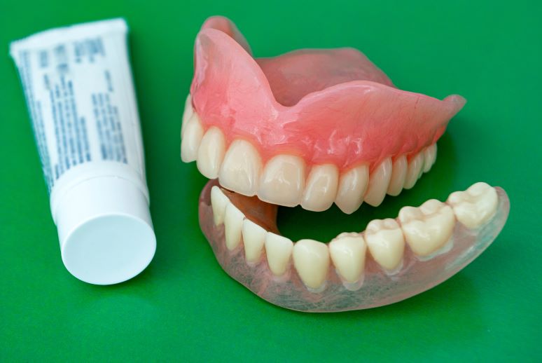 A pair of dentures and denture adhesive.